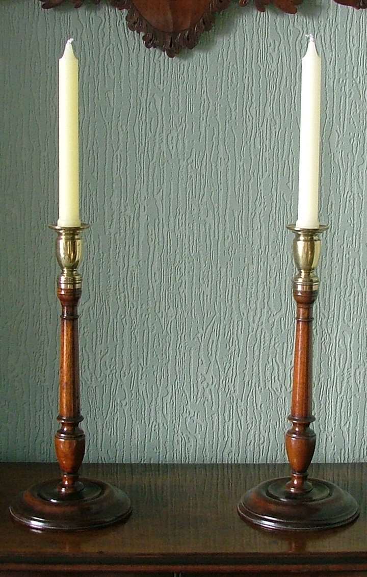 A FINE PAIR OF GEORGE II WALNUT AND BRASS CANDLESTICKS